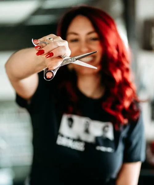 Sara holding a pair of shears out toward the camera